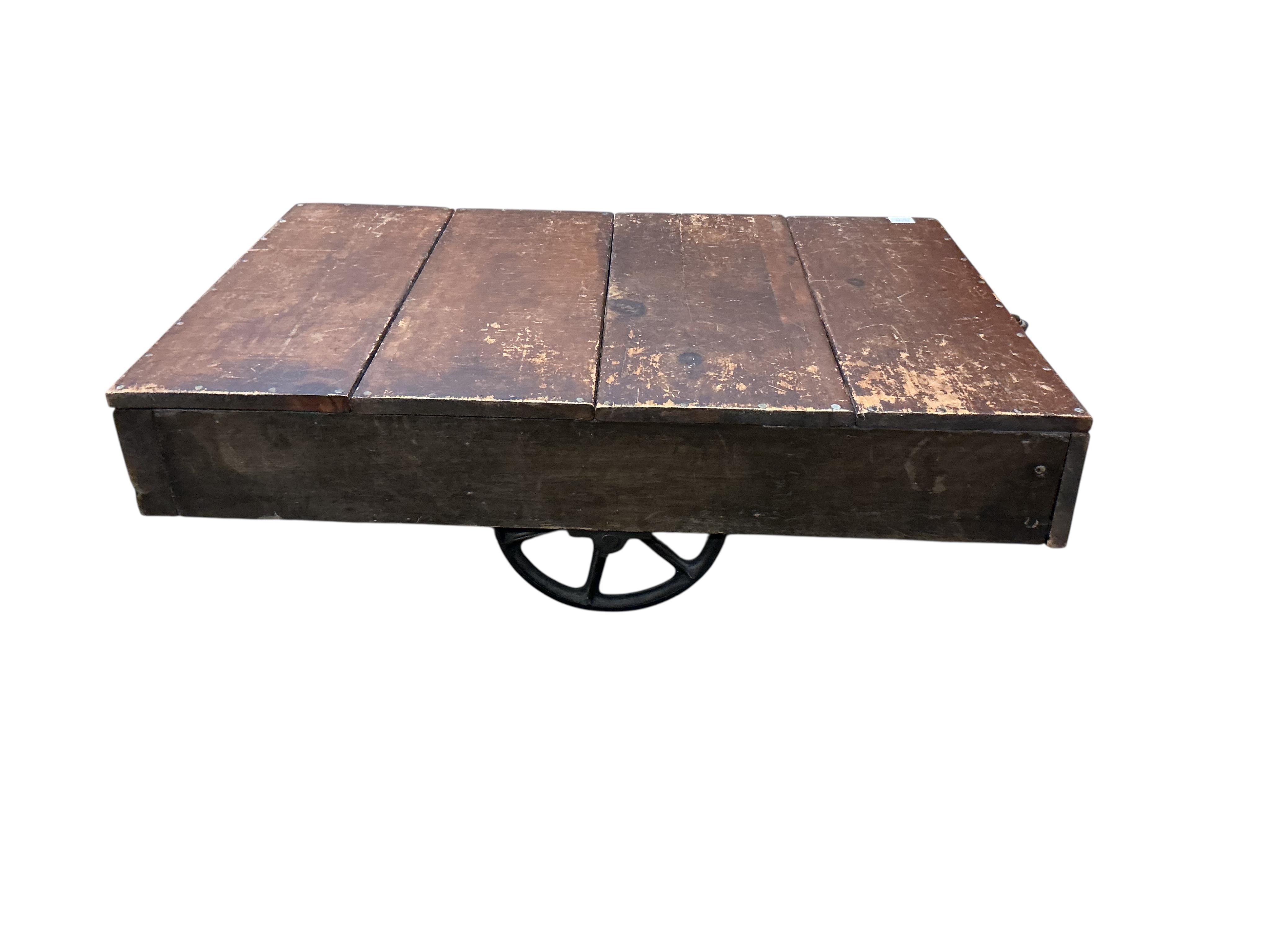 A vintage rectangular wood factory cart with iron spoked wheels now as a coffee table, width 112cm, depth 76cm, height 35cm